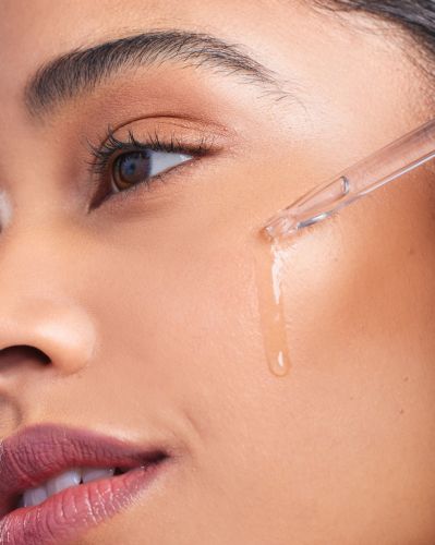 Cropped shot of a woman applying serum to her face - Rhode skincare lawsuit concept