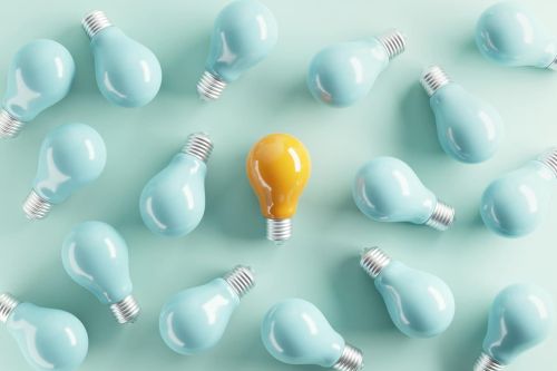 Minimal idea of yellow light bulb surrounded with blue bulbs on pastel background. - inherent distinctiveness concept